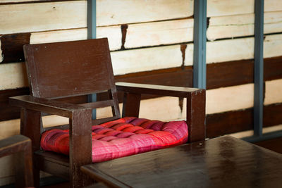 Empty chairs and table against wall