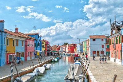 Panoramic view of boats moored in city against sky