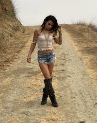 Full length of woman standing on dirt road