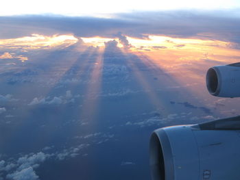 Aerial view of aircraft wing against sky during sunset