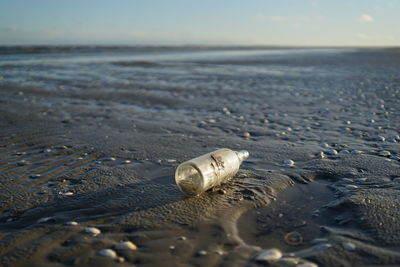 Empty glass bottle at beach