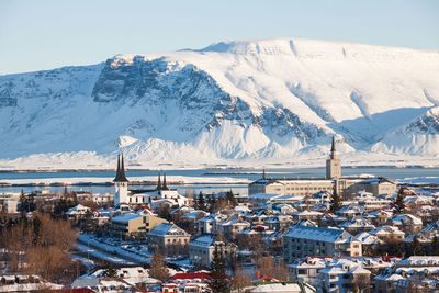 Aerial view of buildings on snowcapped mountain against sky