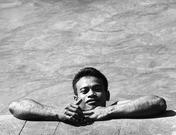 High angle portrait of man leaning at poolside