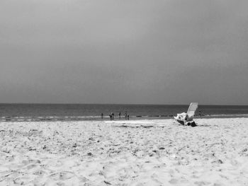 People on beach against clear sky