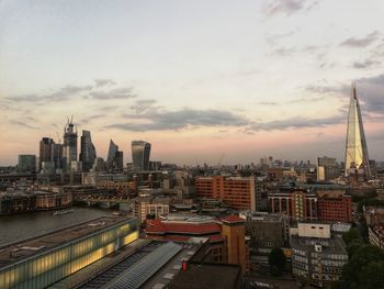 High angle view of city buildings against cloudy sky