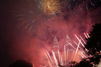 Low angle view of fireworks against sky at night