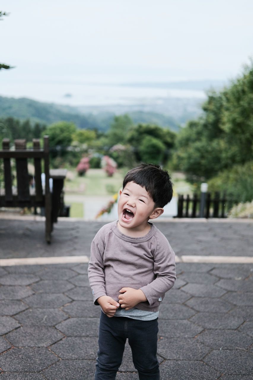 one person, childhood, child, mouth open, men, emotion, casual clothing, day, standing, toddler, person, portrait, clothing, front view, human mouth, nature, full length, focus on foreground, outdoors, shouting, lifestyles, city, spring, tree, innocence, facial expression, footpath, baby, happiness, plant, three quarter length, human face, negative emotion, leisure activity