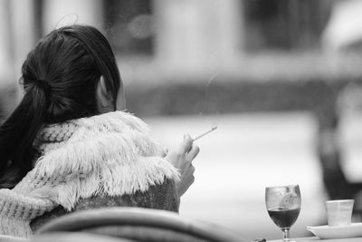 Rear view of woman drinking glass