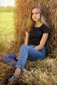 Portrait of young woman sitting on field