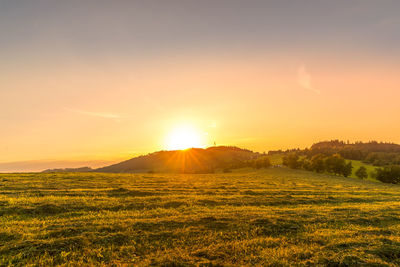 Scenic view of field against sky during sunset