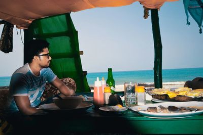 View of man eating at restaurant at beach