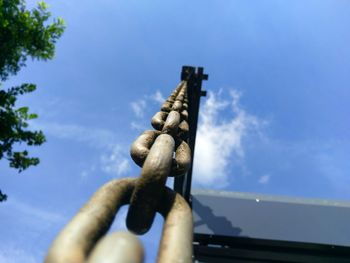 Close-up low angle view of chains against blue sky