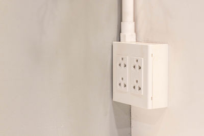 Close-up of electric lamp on wall at home