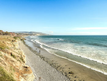 Scenic view of beach against clear blue sky