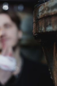 Close-up portrait of woman holding metal