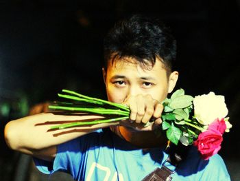 Portrait of young man holding flower bouquet