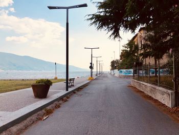 Street by road against sky in city