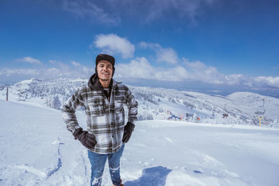 Portrait of man standing on snow covered mountain