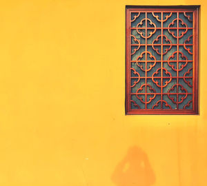 Low angle view of yellow window on building wall