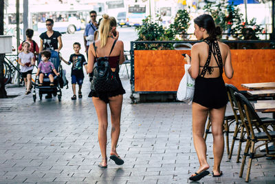 Full length of women walking on street in city