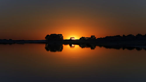 Scenic view of lake against romantic sky at sunset