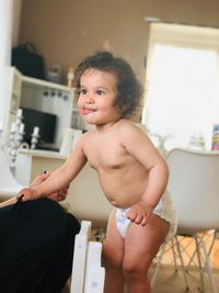 Portrait of shirtless boy sitting at home