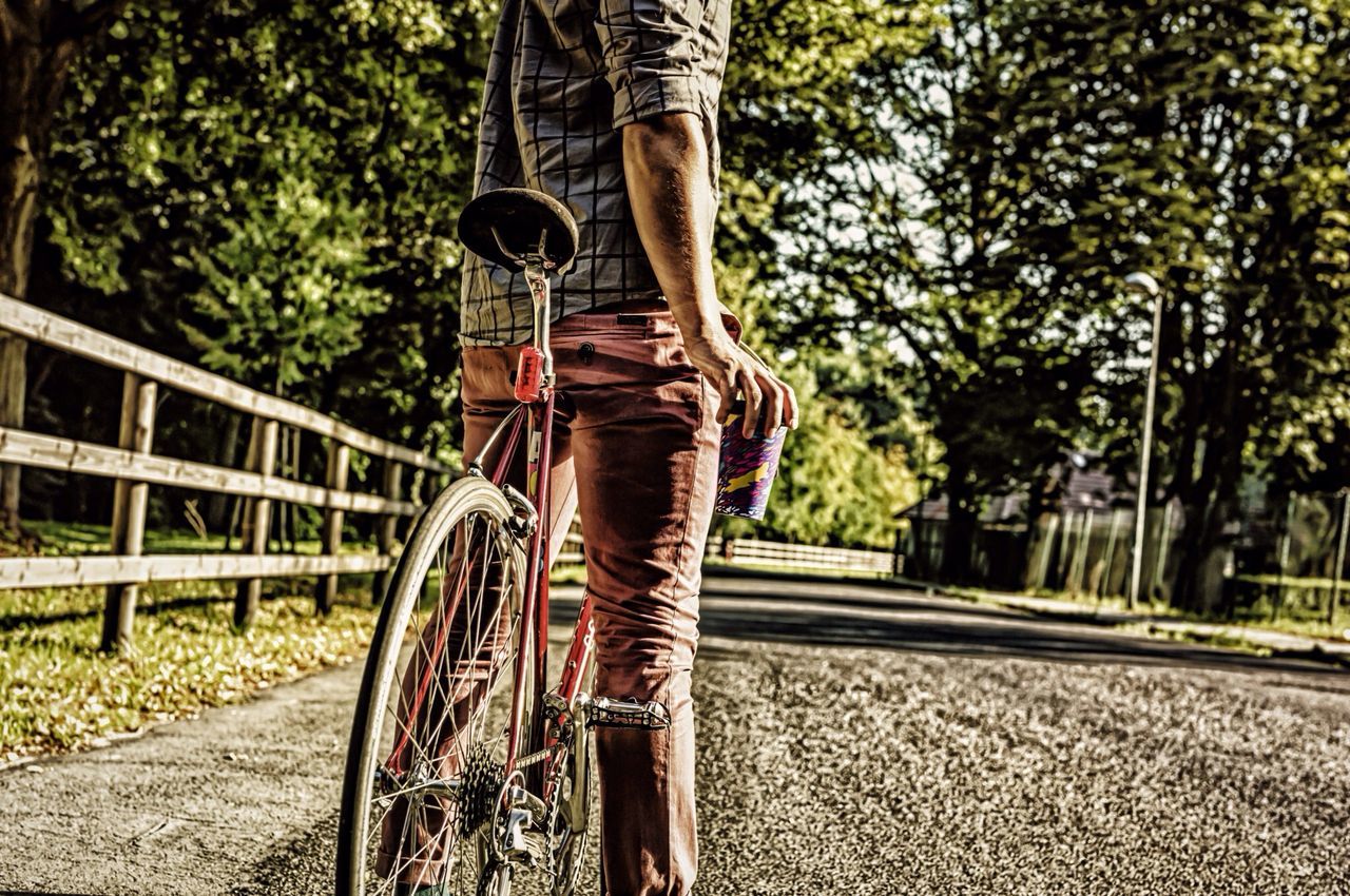 lifestyles, tree, low section, person, leisure activity, casual clothing, men, standing, transportation, bicycle, full length, rear view, street, walking, road, the way forward, outdoors