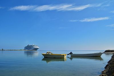 Fishing boats moored in sea against sky