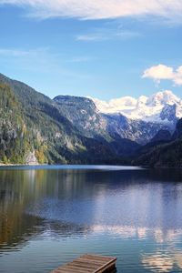 Scenic view of lake by mountains against sky