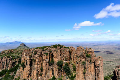 Panoramic view of landscape and mountains against blue sky