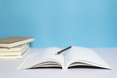 Close-up of open book on table against blue background