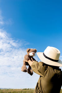 Girl in a linen dress and a straw hat walks . wicker basket in hands. wellness and freedom concept.