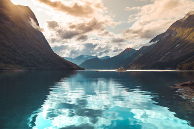 Scenic view of lake by mountains against sky