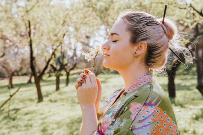 Side view of woman holding plant