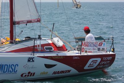 Rear view of people sailing on sea against sky