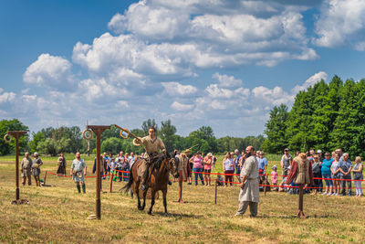 Group of people on field against trees