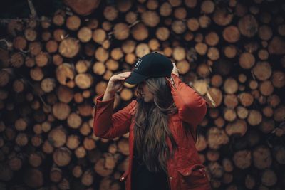 Close-up of woman wearing hat standing on wood