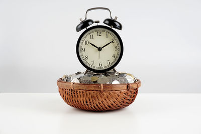 Close-up of clock on table against white background