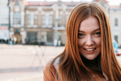 Portrait of smiling young woman in city