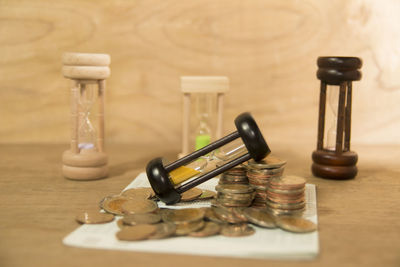 Close-up of coins with hourglasses on table