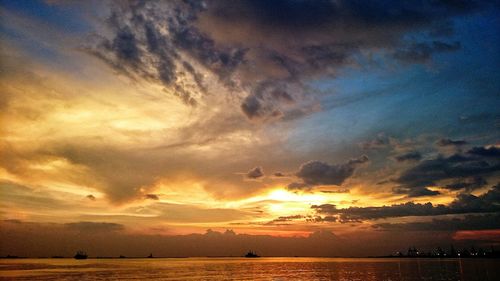 Scenic view of sea against cloudy sky during sunset