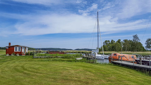 Sailboats moored on land by building against sky