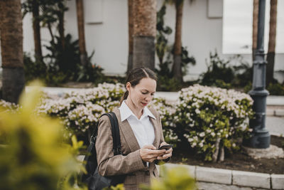 Female professional text messaging through smart phone