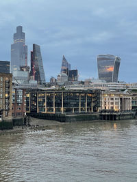 River by buildings against sky in city