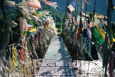 Prayer flags hanging on narrow footbridge