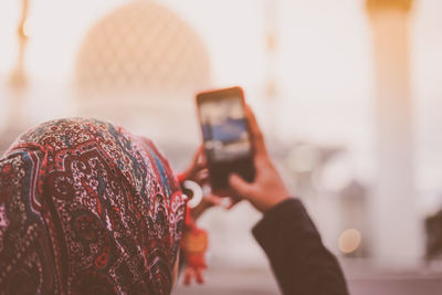 Close-up of woman photographing through smart phone