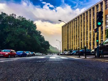 View of city street against cloudy sky