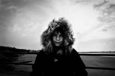 Portrait of boy against railing and sky