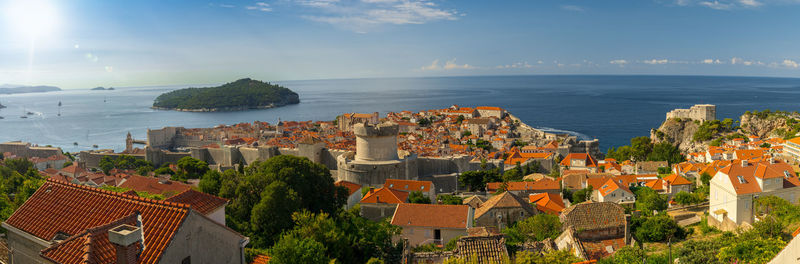 High angle view of townscape by sea against sky