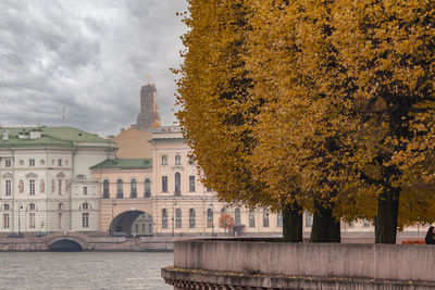 View of buildings in city against cloudy sky